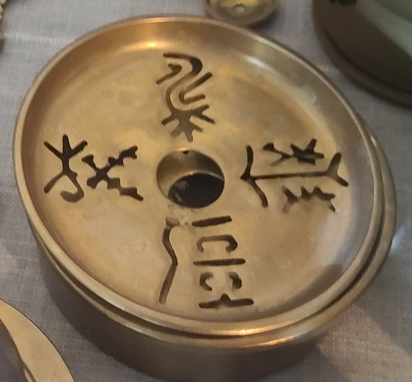 Four lidded brass boxes with lids pierced in archaic-style characters (probably covered ashtrays)