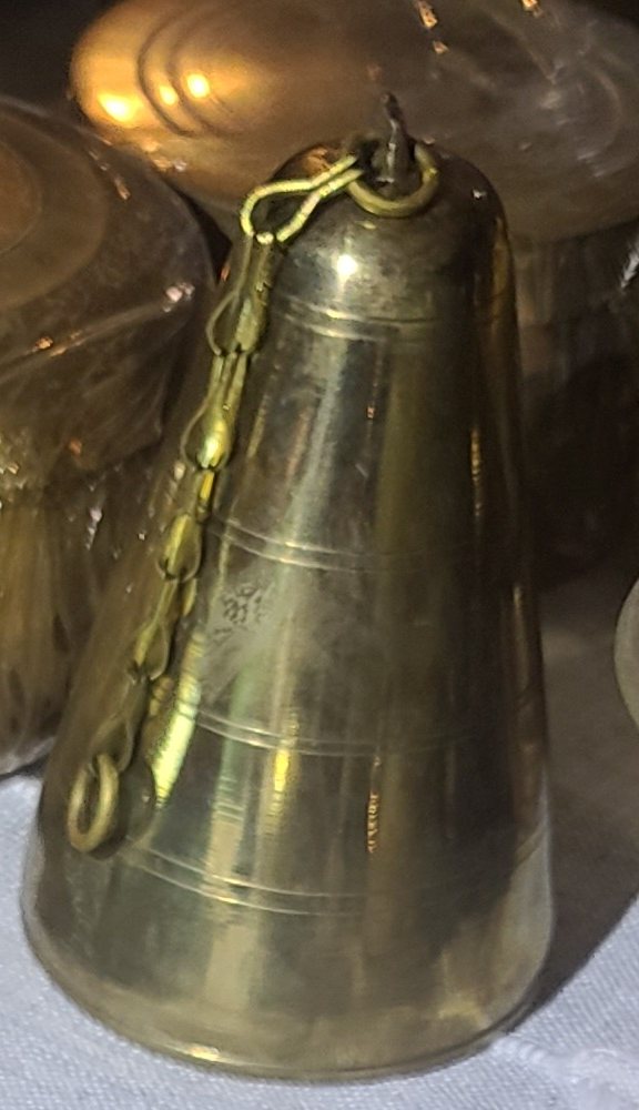 Brass bells, tall chained cone, candlesticks and two domed engraved bases